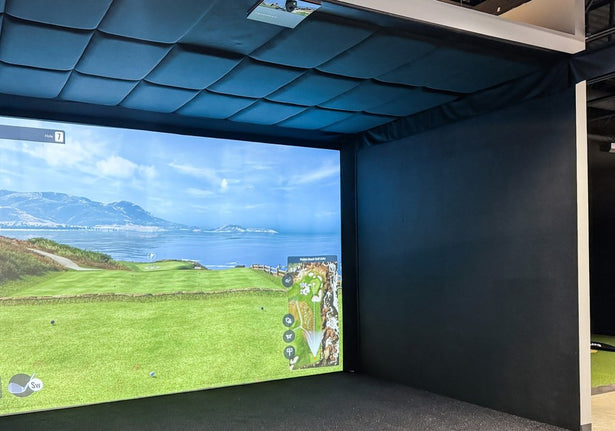 Golf simulator room with acoustic-tiled walls