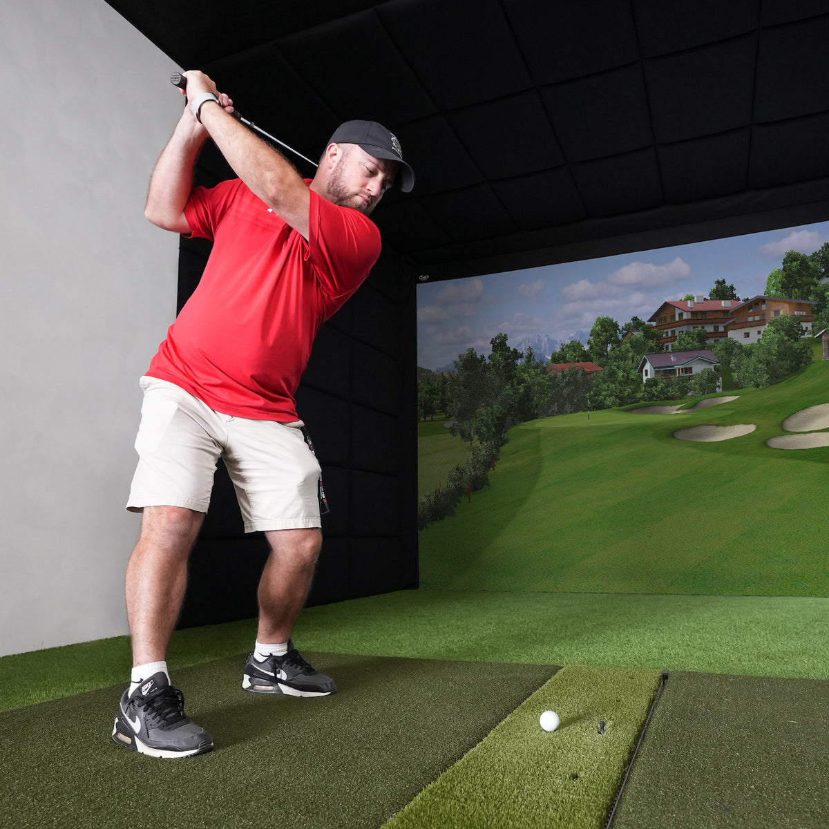 Golfer hitting into a Built-In Golf Room Kit screen