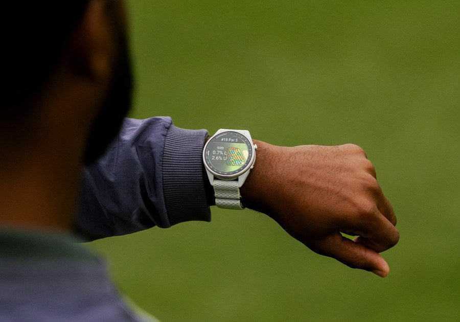 Golfer checking the Garmin Approach S72 47mm Silver/Citron on the course