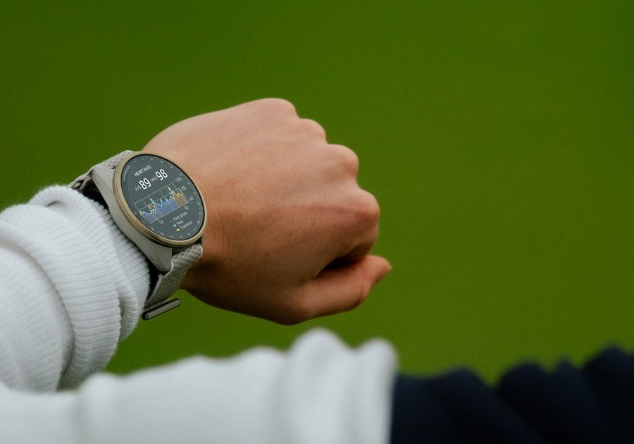 Garmin Approach S72 on a golfer's wrist showing heart rate data on the course